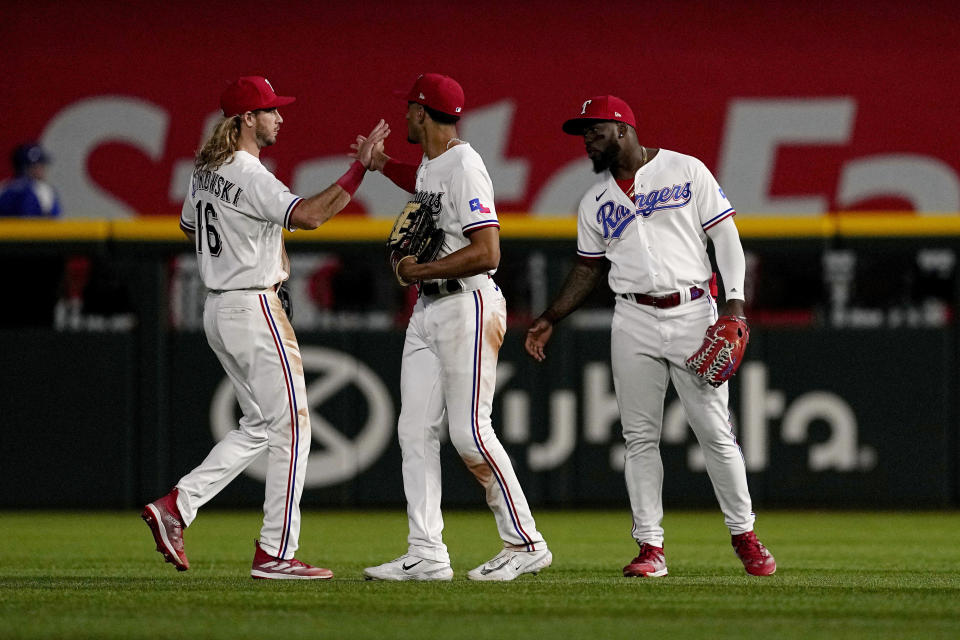 Texas Rangers' Travis Jankowski, Bubba Thompson, center, and Adolis Garcia, right, celebrate after their baseball game against the Kansas City Royals, April 10, 2023, in Arlington, Texas. (AP Photo/Tony Gutierrez)