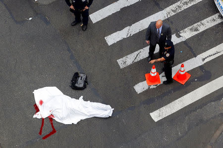 New York Police Department officers stand around a covered body after a shooting in midtown Manhattan in New York, U.S., May 18, 2016. REUTERS/Lucas Jackson