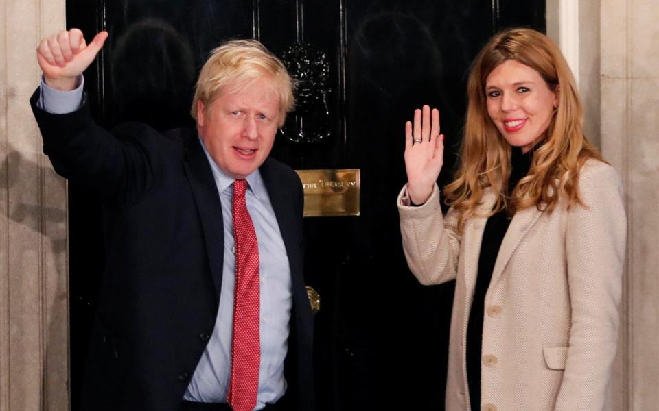 Britain's Prime Minister Boris Johnson and his girlfriend Carrie Symonds gesture as they arrive at 10 Downing Street on the morning after the general election in London, Britain, December 13, 2019 - REUTERS/Thomas Mukoya