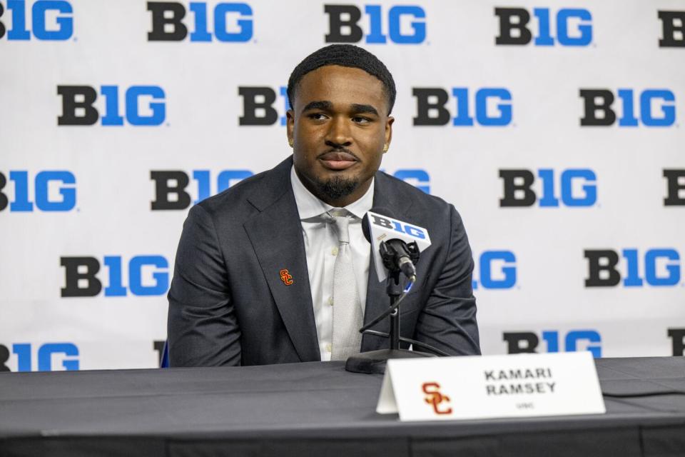 USC's Kamari Ramsey sits in a suit behind a microphone and answers questions from reporters during Big Ten media days