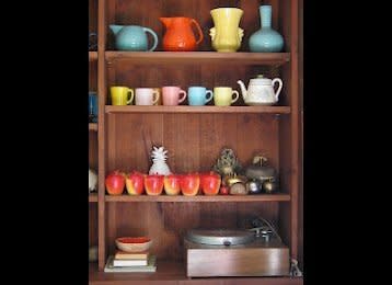 Rosen's guestroom shelves contain a lively selection of colorful ceramics, both new and old. 