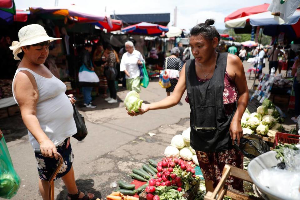 Una mujer vende verduras, el de 10 julio de 2024, a las afueras del mercado central en San Salvador, El Salvador. El Mercado Central de San Salvador es un río, un flujo incesante de colores, de aromas y texturas.