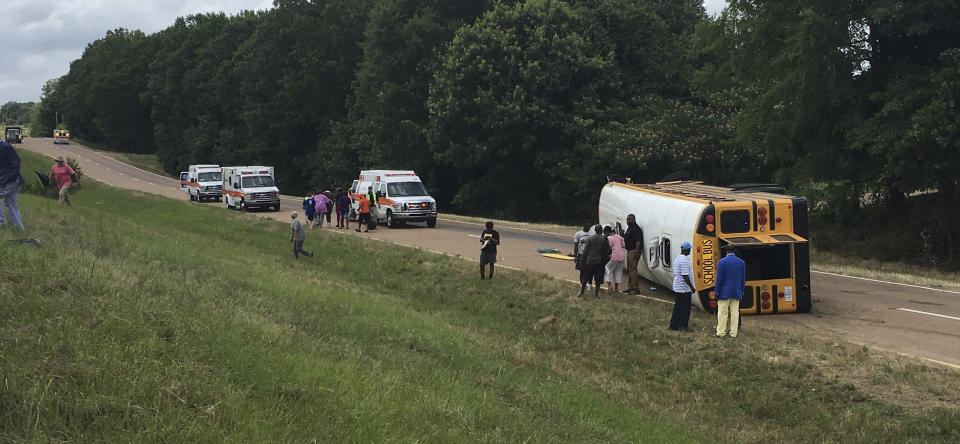 This photograph provided by Ken Strachan, director of the Carroll County Emergency Management/Civil Defense Agency, shows a Greenwood School District school bus on its side on U.S. 82 near McCarley Road in Carroll County, Mississippi, Monday, June 17, 2019. Several Greenwood High School students were injured in the one-vehicle accident and were taken to area hospitals. (Ken Strachan/The Carroll County Emergency Management/Civil Defense Agency)