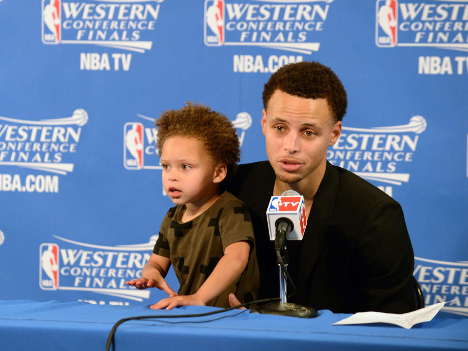 Stephen Curry #30 of the Golden State Warriors and his daughter Riley talking with the media at a press conference after the game against the Houston Rockets during Game One of the Western Conference Finals during the NBA Playoffs on May 19, 2015 at ORACLE Arena in Oakland, California.  (Noah Graham / NBAE via Getty Images)