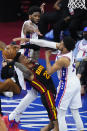 Atlanta Hawks' John Collins, left, tries to get a shot past Philadelphia 76ers' Joel Embiid, center, and Tobias Harris during the first half of Game 7 in a second-round NBA basketball playoff series, Sunday, June 20, 2021, in Philadelphia. (AP Photo/Matt Slocum)