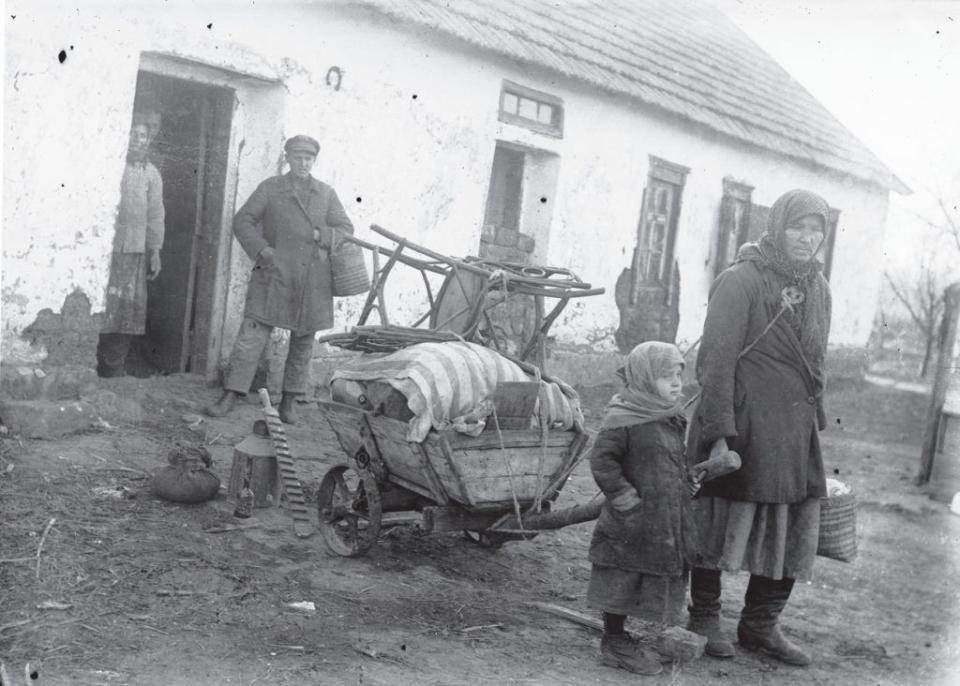 A distraught family, after just having all of their belongings forcefully taken away by the Soviets, stands near their house in the village of Udachne, Donetsk region. 1930s. (Marko Zalizniak/The National Museum of the Holodomor-Genocide)