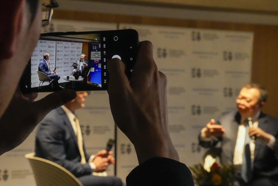 A guest films Liu Jianchao, right, Minister of the International Department of the Central Committee of the Communist Party of China, answers questions following his address at University of Technology Sydney, in Sydney, Australia, Tuesday, Nov. 28, 2023. (AP Photo/Mark Baker)