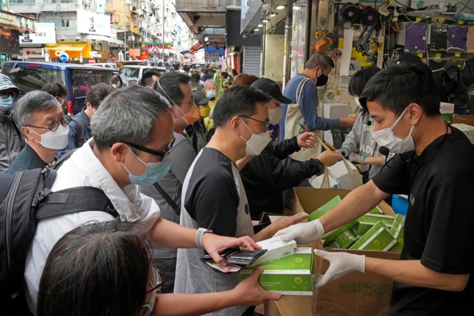 ▲香港可能即將實施全民強檢，搭配有限度禁足措施。圖為香港民眾排隊領取檢測盒。（圖／美聯社／達志影像）