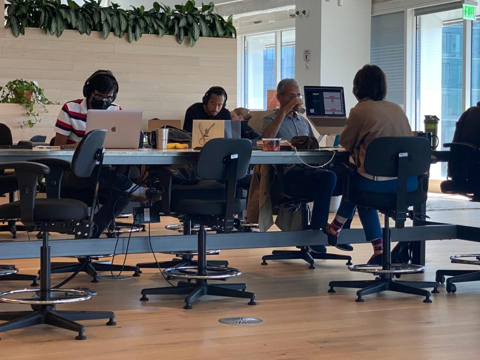 Tech workers, some wearing facemasks, work inside a downtown San Francisco coworking space. (Josh Marcus / The Independent)