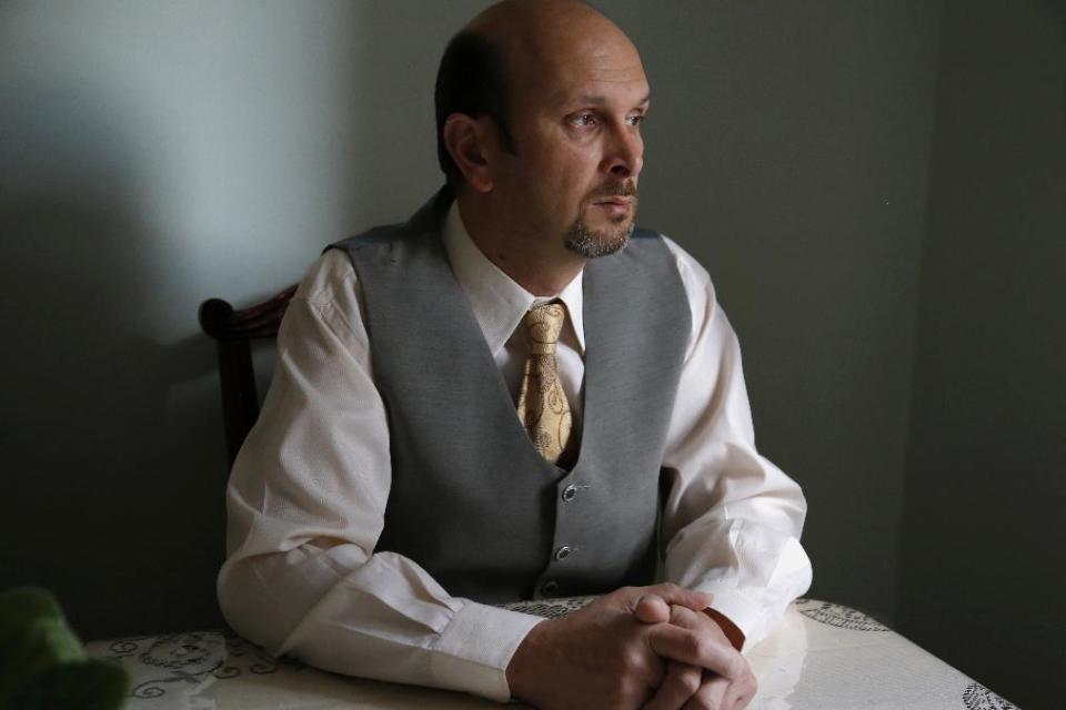 This photo taken Feb. 7, 2014 shows real estate agent Morteza Assadi, 49, in his home in Vienna, Va., Friday, Feb. 7, 2014. The Obama administration has eased the rules for would-be asylum seekers, refugees and others who hope to come to the United States or stay here and who gave ``limited” support to terrorists or terrorist groups. For Assadi, the law has left him in a sort of immigration purgatory while his green card application has been on hold for more than a decade. (AP Photo/Charles Dharapak)