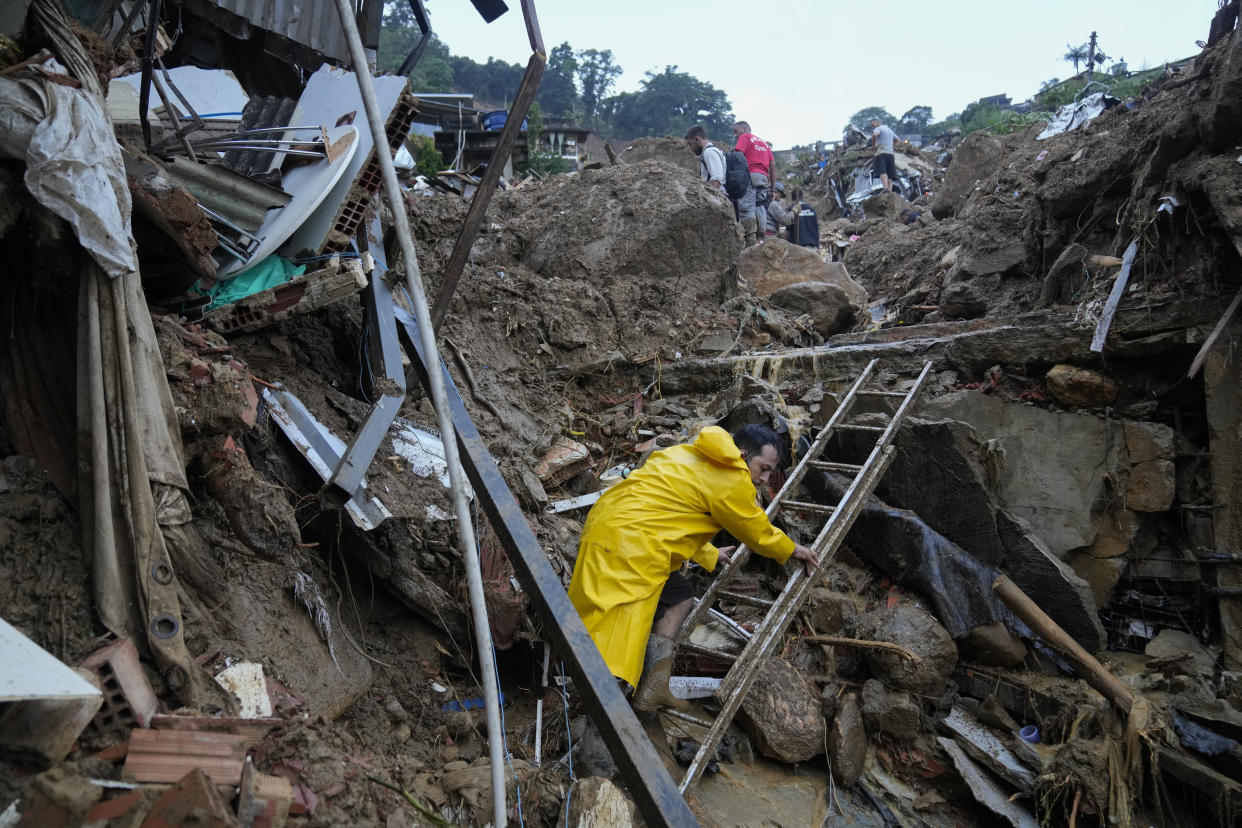 Rescue workers and residents search for victims in an area affected by landslides in Petropolis, Brazil, Wednesday, Feb. 16, 2022. Extremely heavy rains set off mudslides and floods in a mountainous region of Rio de Janeiro state, killing multiple people, authorities reported. (AP Photo/Silvia Izquierdo)