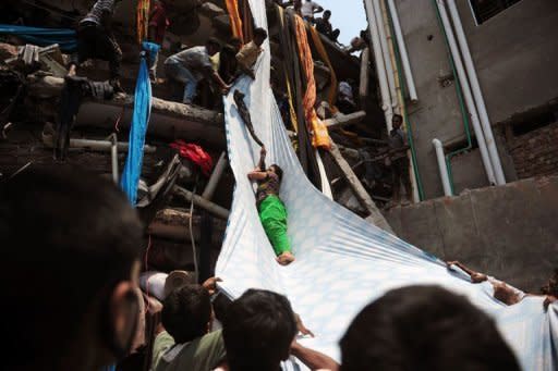 Una superviviente al derrumbe del edificio es evacuada con una gran tela a modo de tobogán, este miércoles en Dacca.