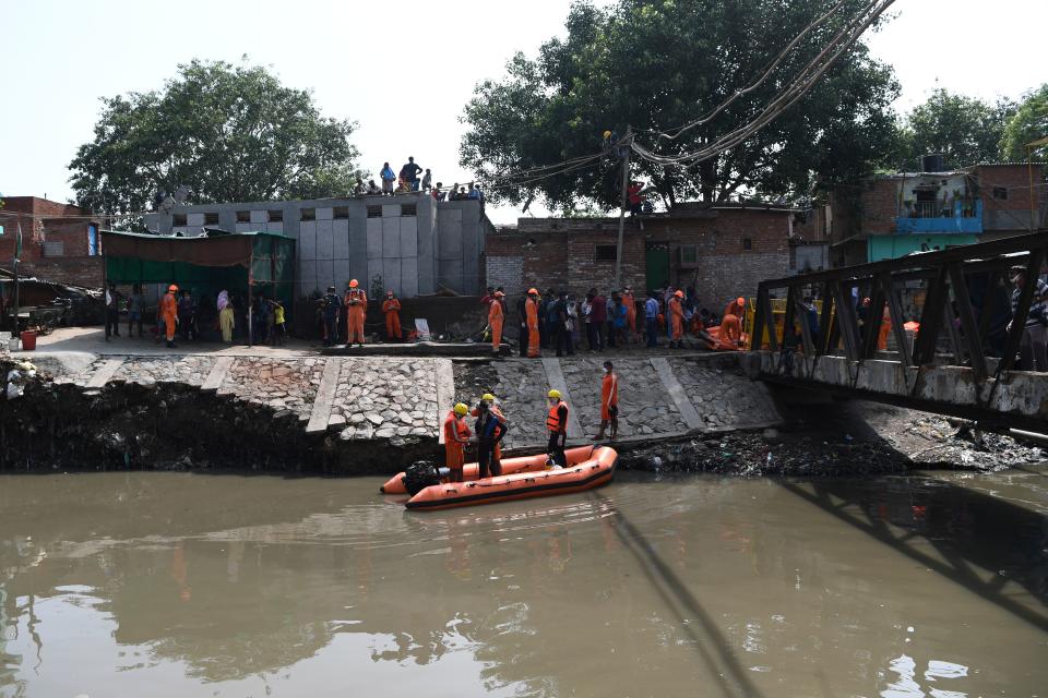 National Disaster Response Force personnel prepare to inspect on a dinghy the area where some shanty houses collapsed into a canal due to heavy rains in New Delhi on July 19, 2020. (Photo by Sajjad HUSSAIN / AFP) (Photo by SAJJAD HUSSAIN/AFP via Getty Images)