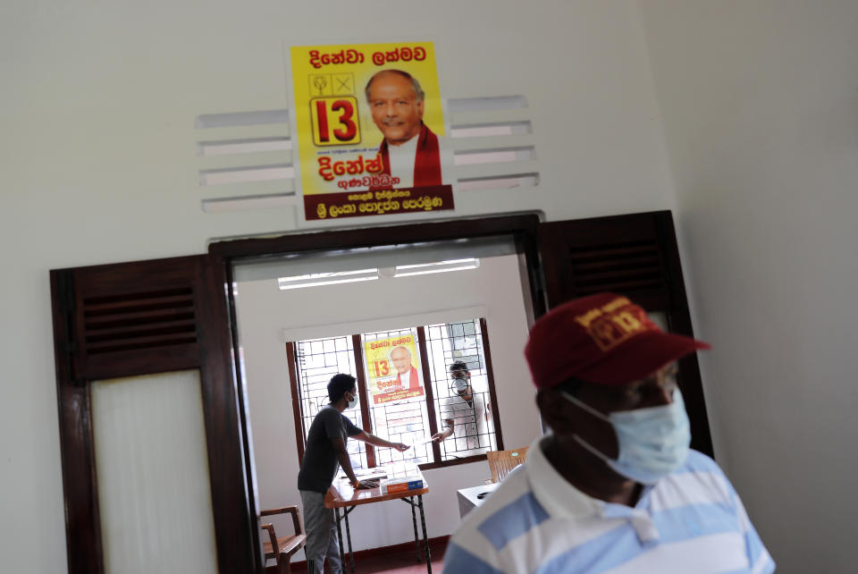 Election propaganda of Sri Lanka's Foreign Minister Dinesh Gunawardena is seen pasted on a wall at a party office in Colombo, Sri Lanka, Monday, July 27, 2020. Sri Lankans are voting in parliamentary elections Wednesday that are expected to strengthen President Gotabaya Rajapaksa's grip on power. Parts of the party are also calling for a two-thirds majority in Parliament so it can amend the constitution to restore presidential powers curbed by a 2015 constitutional change. (AP Photo/Eranga Jayawardena)