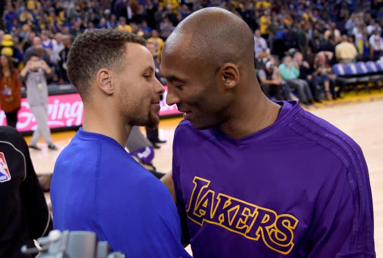 Stephen Curry (L) of the Golden State Warriors meets at center court with Kobe Bryant of the Los Angeles Lakers prior to the start of their NBA basketball game on November 24, 2015 in Oakland, California