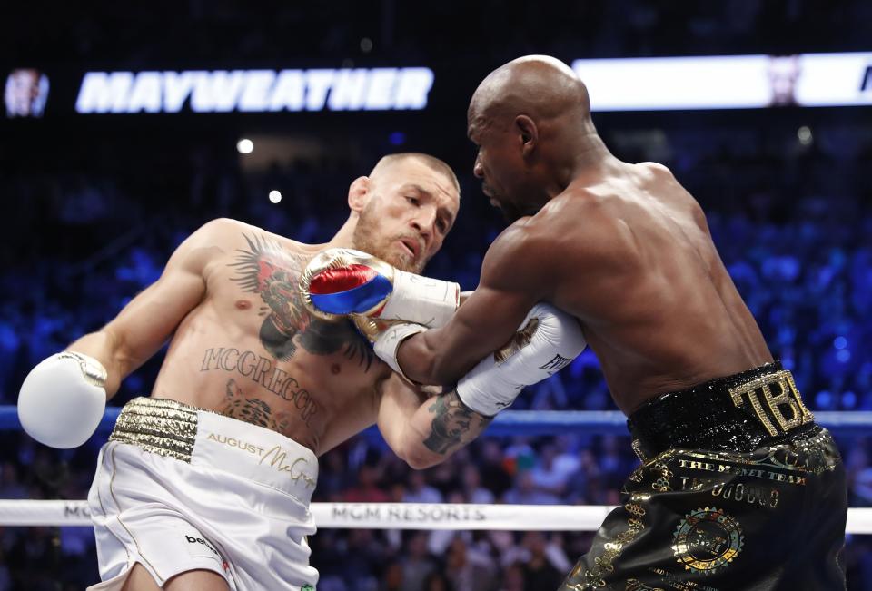 <p>Conor McGregor in action with Floyd Mayweather Jr. REUTERS/Steve Marcus </p>