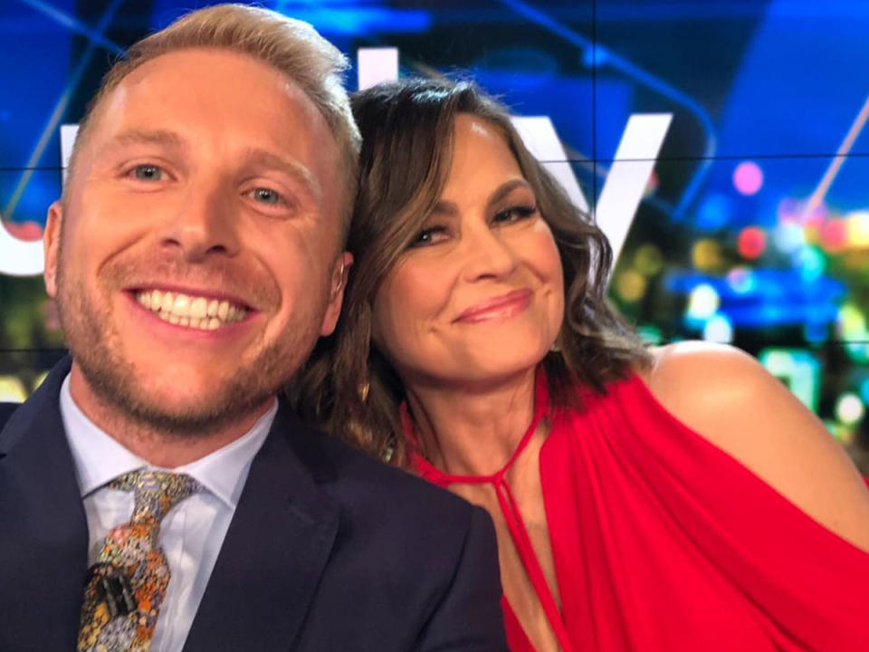 Lisa Wilkinson with co host on the set of The Project, she is wearing a red top.