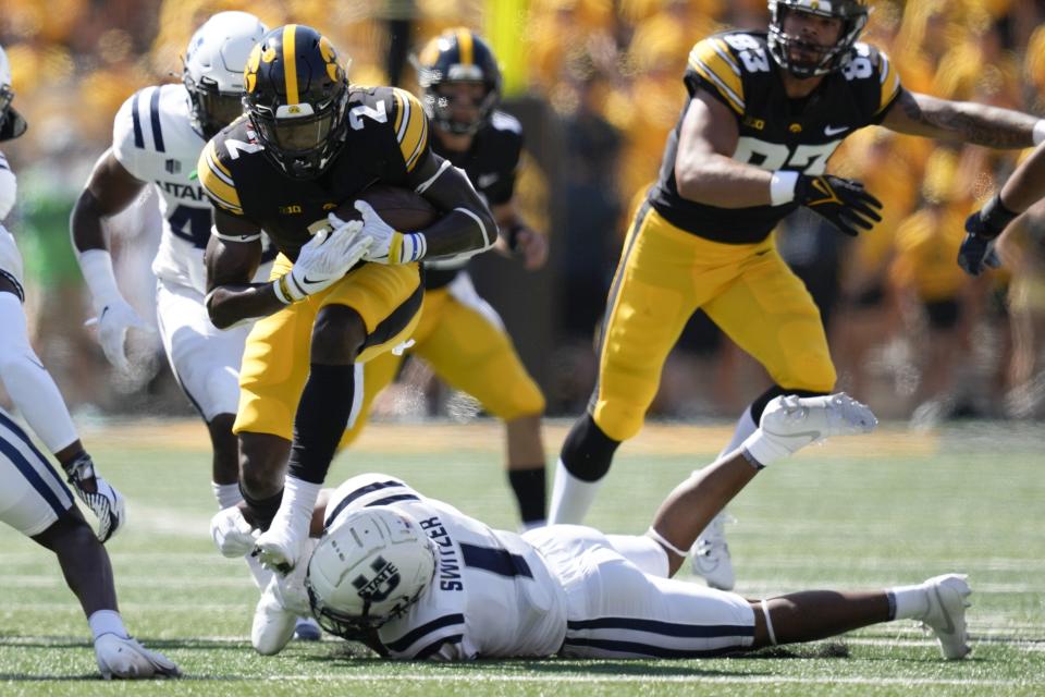 Iowa running back Kaleb Johnson (2) tries to break a tackle by Utah State safety Anthony Switzer (1) during the first half of an NCAA college football game, Saturday, Sept. 2, 2023, in Iowa City, Iowa. (AP Photo/Charlie Neibergall) | AP