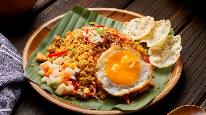Fried egg and rice on wooden plate
