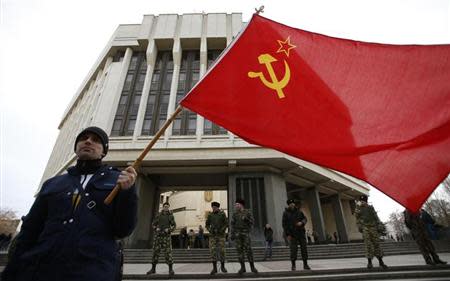 A man holds a Soviet Union flag as he attends a pro-Russian rally at the Crimean parliament building in Simferopol March 6, 2014. REUTERS/David Mdzinarishvili