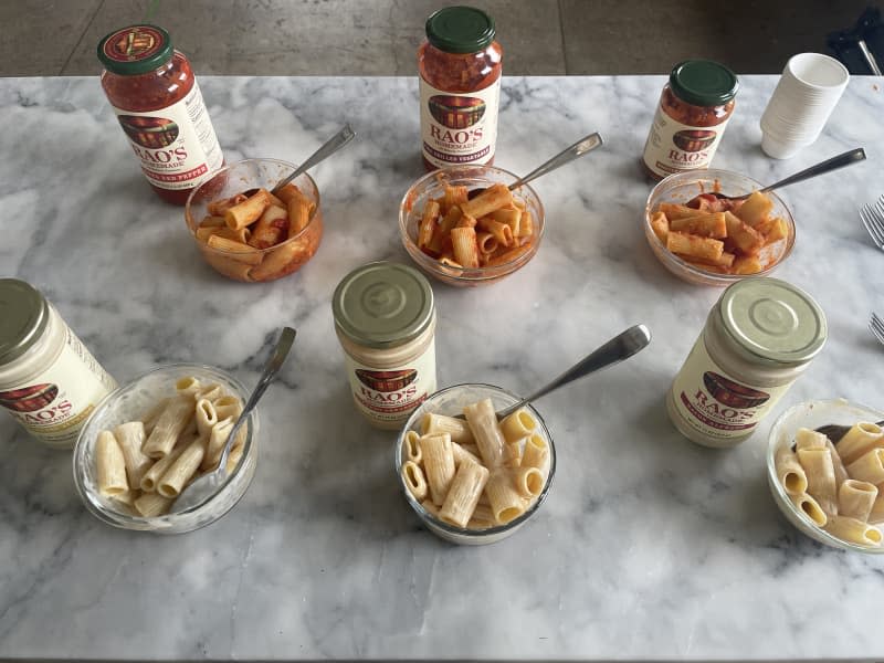 Rao's new sauces taste test: jars of sauce on counter next to bowls of rigatoni