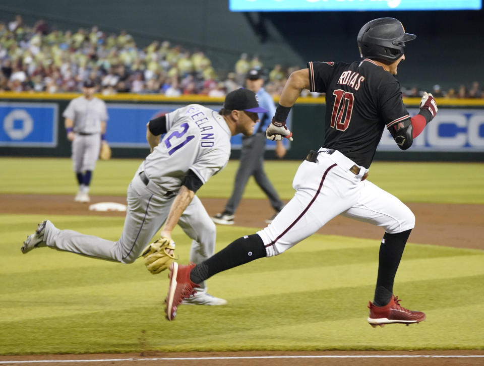 Arizona Diamondbacks' Josh Rojas runs out a bunt as Colorado Rockies pitcher Kyle Freeland fields the ball during the first inning of a baseball game Saturday July 9, 2022, in Phoenix. (AP Photo/Darryl Webb)