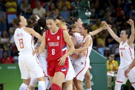 2016 Rio Olympics - Basketball - Women's Semifinal Spain v Serbia - Carioca Arena 1 - Rio de Janeiro, Brazil - 18/8/2016. Players from Spain celebrate as Sasa Cado (SRB) of Serbia walks off the court. REUTERS/Shannon Stapleton