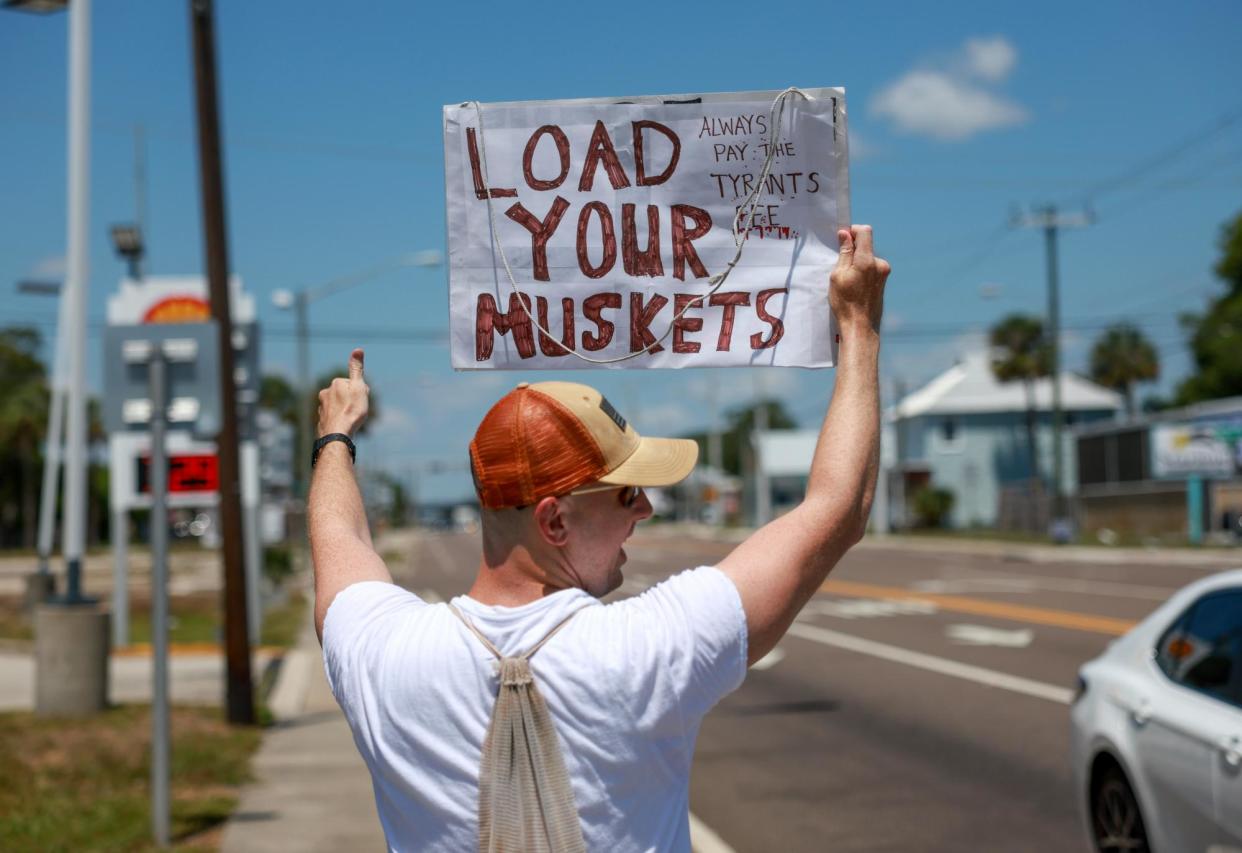 <span>Mark Fuller of Titusville, Florida, shows his support for Trump on 31 May 2024.</span><span>Photograph: Joe Raedle/Getty Images</span>
