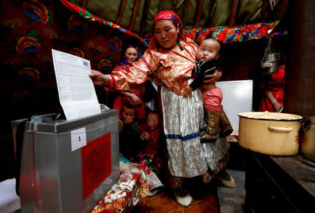 Members the indigenous community "Yamb To" (Long Lake) take part in the early voting in remote areas ahead of the presidential election, at a reindeer camping ground, about 450 km northeast of Naryan-Mar, in Nenets Autonomous District, Russia, March 1, 2018. REUTERS/Sergei Karpukhin