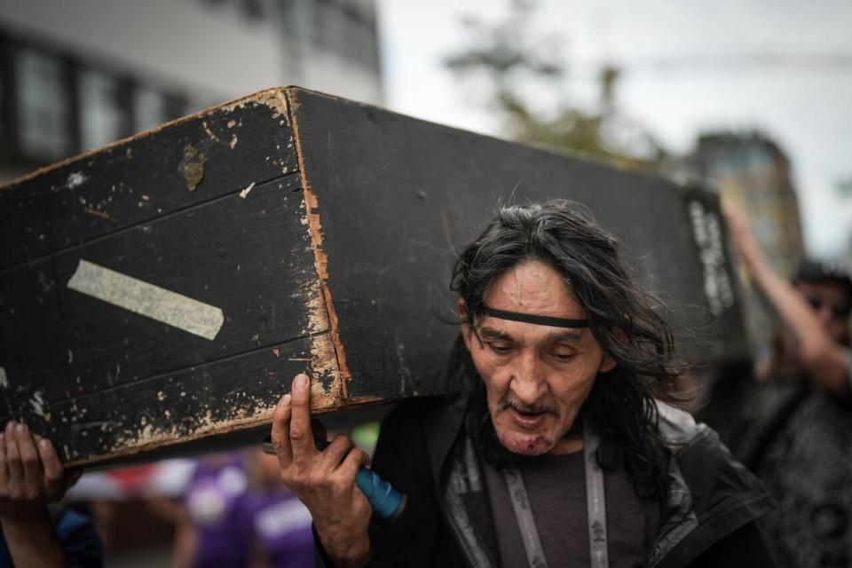 Carl Gladue helps carry an empty coffin during a march organized by the Vancouver Area Network of Drug Users (VANDU) to mark International Overdose Awareness Day in Vancouver on Thursday, August 31, 2023. (Darryl Dyck/The Canadian Press - image credit)