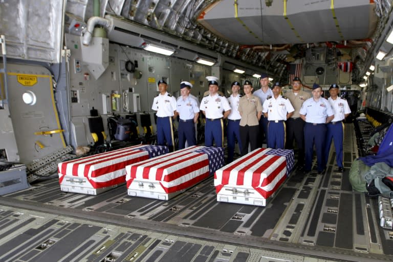 US troops standing next to three flag-draped coffins bearing the remains of American soldiers killed in Vietnam whose remains were only recently recovered