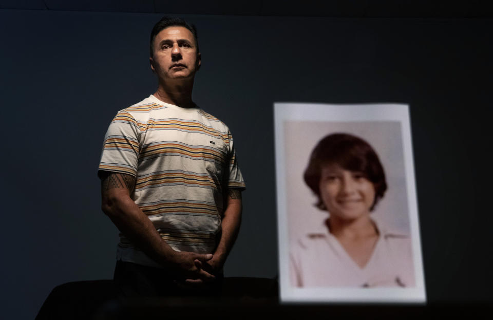 Walter Denton, 55, stands behind a photo of himself when he was about 12 years old, in Hagatna, Guam, Monday, May 13, 2019. Denton says he was raped at age 13 by then-Archbishop of Agana, Anthony Apuron. "This whole thing changed my whole life," said Denton. "He took everything from me. From that day forward my demeanor changed. I break down, I hurt everyday and I still hurt. It's something that I'll never get over." Apuron denies the allegations, which are detailed in a lawsuit. (AP Photo/David Goldman)