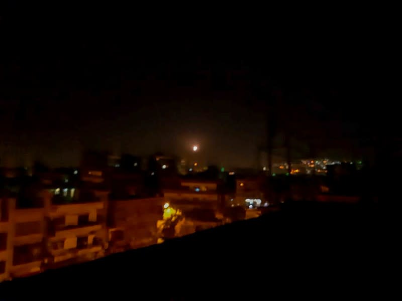 Light in the sky, believed to be a missile, is seen the city in Damascus
