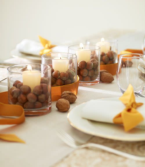 <p>Basic votive holders instantly look festive once they're filled with unshelled walnuts, chestnuts or acorns.</p>