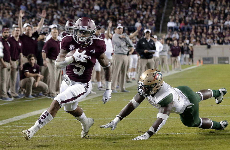 Texas A&M running back Trayveon Williams (5) dodges the tackle attempt by UAB linebacker Chris Woolbright, right, to score during the first half of an NCAA college football game Saturday, Nov. 17, 2018, in College Station, Texas. (AP Photo/Michael Wyke)