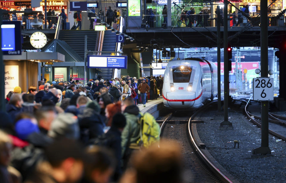 Numerous travelers wait for their train on a full platform at the main station in Hamburg, Germany, Friday Dec. 22, 2023. Pre-Christmas rail travelers in parts of Germany faced widespread disruption on Friday as a storm swept across northern Europe, bringing down trees and prompting warnings of flooding on the North Sea coast. (Christian Charisius/dpa via AP)