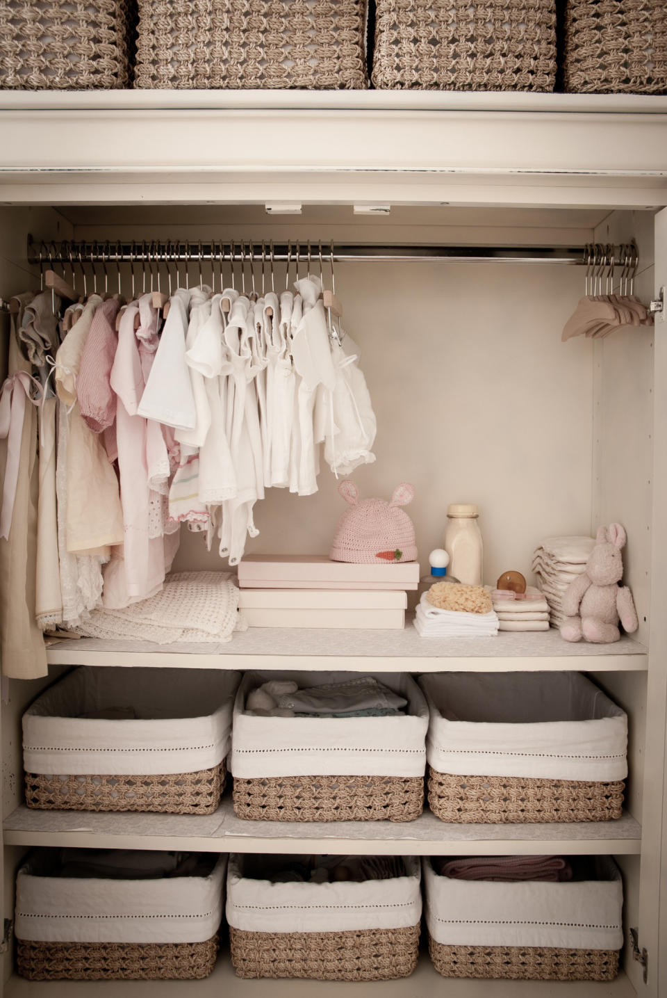 Baby clothes hanging in nursery closet.