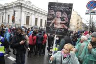 Demonstrators, one of them holding a poster reading "No medical experiments will protect our children" gather for an anti-vaccination protest in Kyiv, Ukraine, Wednesday, Nov. 3, 2021. In a bid to stem contagion, Ukrainian authorities have required teachers, government employees and other workers to get fully vaccinated by Nov. 8 or face having their salary payments suspended. In addition, proof of vaccination or a negative test is now required to board planes, trains and long-distance buses. (AP Photo/Efrem Lukatsky)