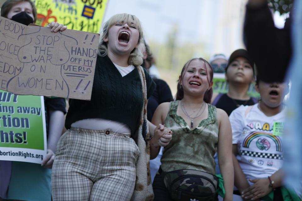 Protesters holding signs chant