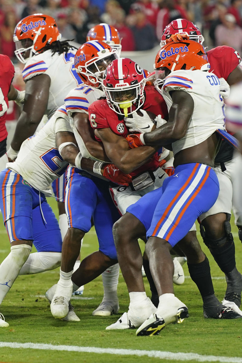 Georgia running back Kenny McIntosh, center, scores a touchdown a he pushes his way past Florida linebacker Ventrell Miller, left, and safety Corey Collier Jr. during the second half of an NCAA college football game Saturday, Oct. 29, 2022, in Jacksonville, Fla. (AP Photo/John Raoux)