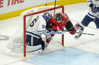 Chicago Blackhawks' Philipp Kurashev, right, skates into Toronto Maple Leafs goaltender Jack Campbell during the third period of an NHL hockey game Wednesday, Oct. 27, 2021, in Chicago. Kurashev, was called for goalie interference. The Maple Leafs won in overtime 3-2. (AP Photo/Charles Rex Arbogast)