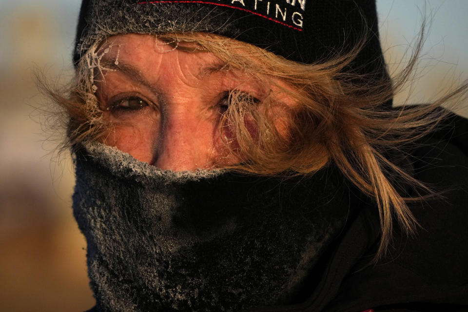 Frost clings to the hair of Joyce Love as she looks at arctic sea smoke on the coast of South Portland, Maine, Saturday, Feb. 4, 2023. The morning temperature was about -10 degrees Fahrenheit. (AP Photo/Robert F. Bukaty)