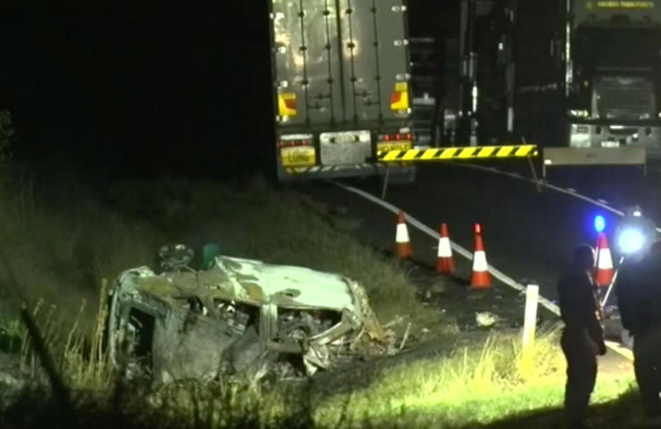 The scene of the crash on the Bunya Highway near Kumbia. Police are seen next to a crushed car which sits on the side of the road.