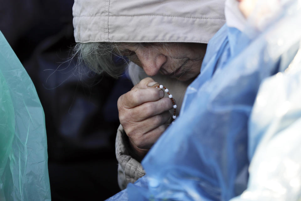 A woman prays as she waits for the arrival of Pope Francis to celebrate mass, at the Santakos Park, in Kaunas, Lithuania, Sunday, Sept. 23, 2018. (AP Photo/Andrew Medichini)