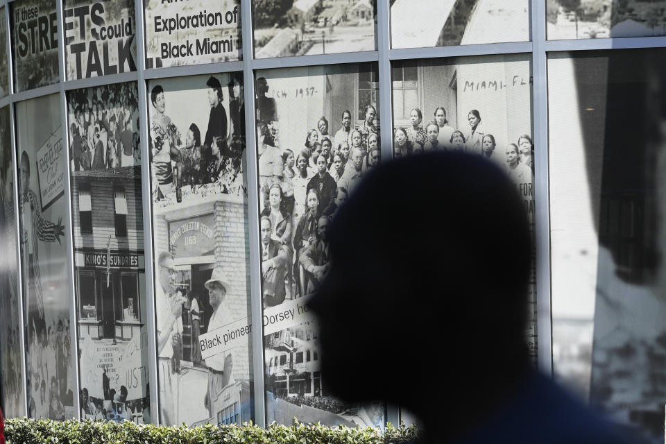 Marvin Dunn is silhouetted in front of a mural at the Lyric Theater Sunday, Feb. 25, 2024, in Miami. Dunn, a professor emeritus at Florida International University and the author of many books on the history of African Americans in Florida, was leading a tour of Overtown, a historically Black neighborhood undergoing gentrification. (AP Photo/Marta Lavandier)