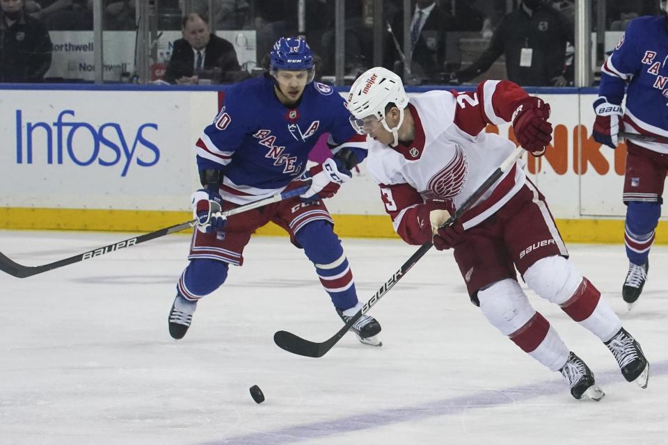 Detroit Red Wings left wing Lucas Raymond (23) controls puck around New York Rangers left wing Artemi Panarin (10) during second period of NHL hockey game, Saturday April 16, 2022, in New York. (AP Photo/Bebeto Matthews)