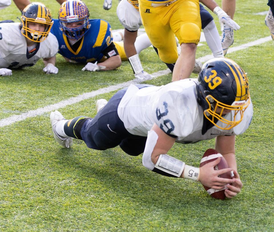 Kirtland’s Macguire Boyd recovers the ball he stripped from Marion Local’s Darren Meier in the Division VI state final, Saturday, Dec. 3, 2022, at Tom Benson Hall of Fame Stadium.