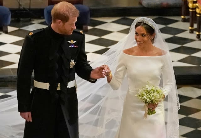 Prince Harry, Duke of Sussex (L) and Britain’s Meghan Markle, Duchess of Sussex, (R) walk away from the High Altar toward the West Door to exit at the end of their wedding ceremony in St George’s Chapel, Windsor Castle, in Windsor, on May 19, 2018 [Photo credit should read OWEN HUMPHREYS/AFP via Getty Images]