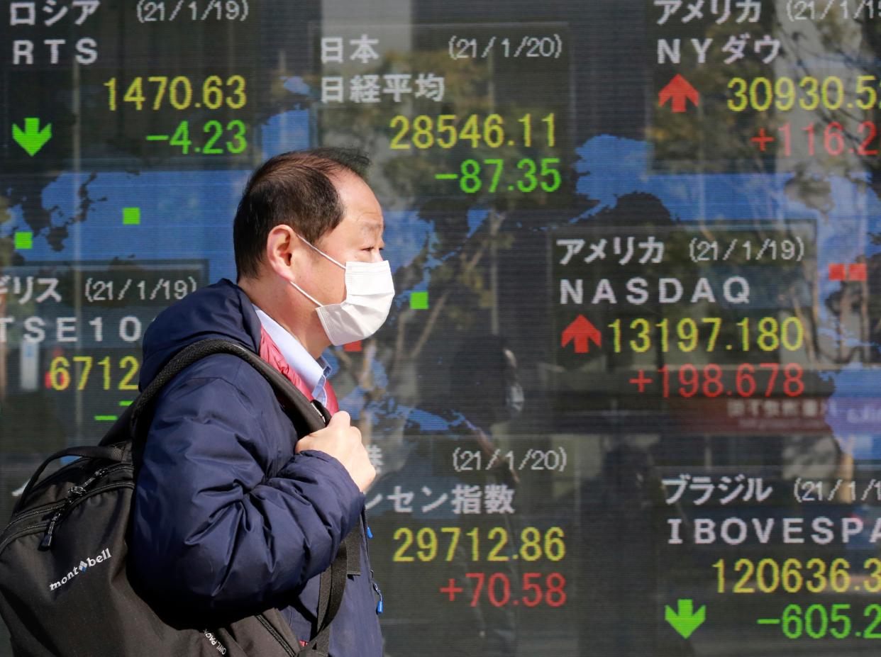 A man walks by an electronic stock board of a securities firm in Tokyo (AP)