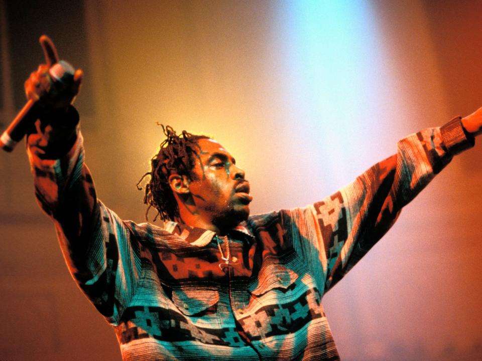 Coolio performs on a red-lit stage.